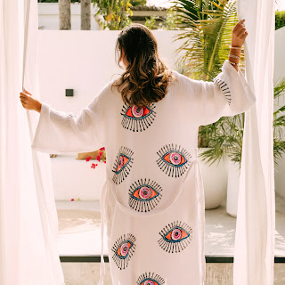 A light white flowing kaftan styled simply to highlight its airy fabric and elegant look