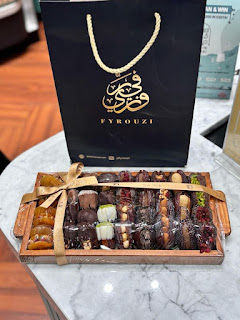 A decorative tray filled with dates arranged neatly alongside a ceramic dish, reflecting a refined and traditional host gift presentation